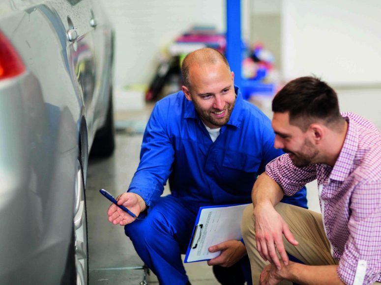 Mechaniker und Kunden besprechen Herstellergarantie beibehalten bei TOP Markenspezialist Auto Bühne. Spezialist für Volkswagen